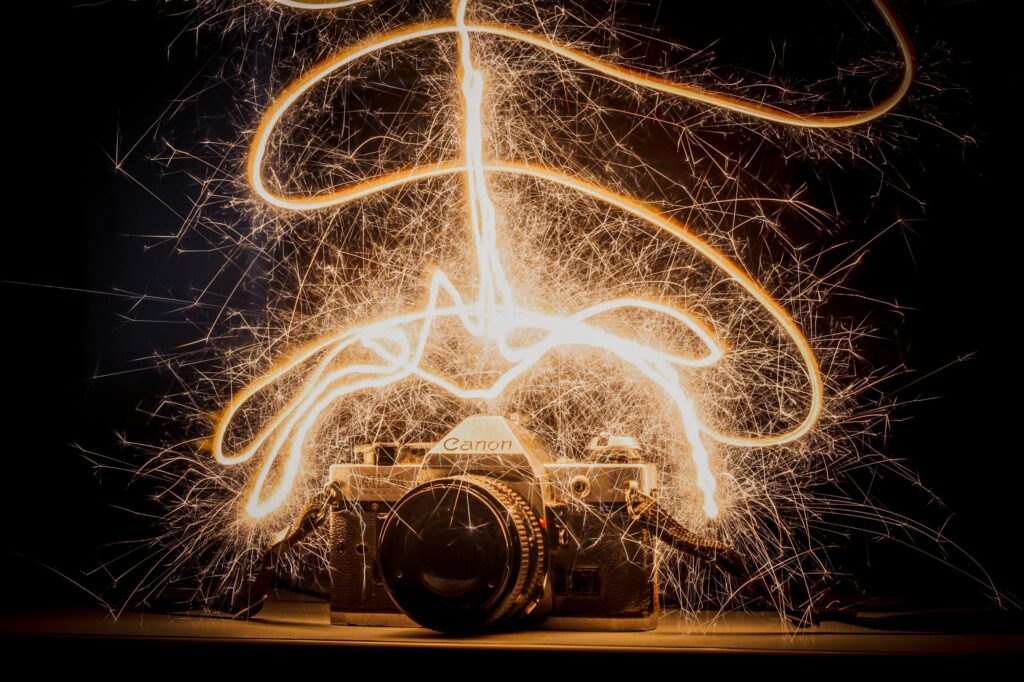 Antique camera with dynamic sparkler light trails. Captivating long exposure shot.